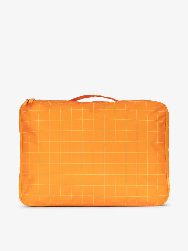 CALPAK large packing cubes with top handle in orange and white grid print