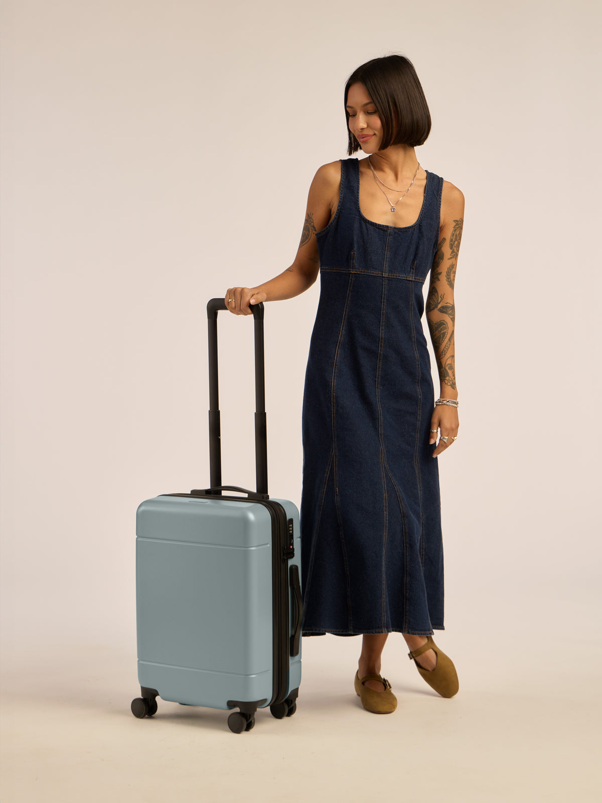 Model with CALPAK Hue Carry-On Luggage in blue Bluebell; LHU1020-NP-BLUEBELL