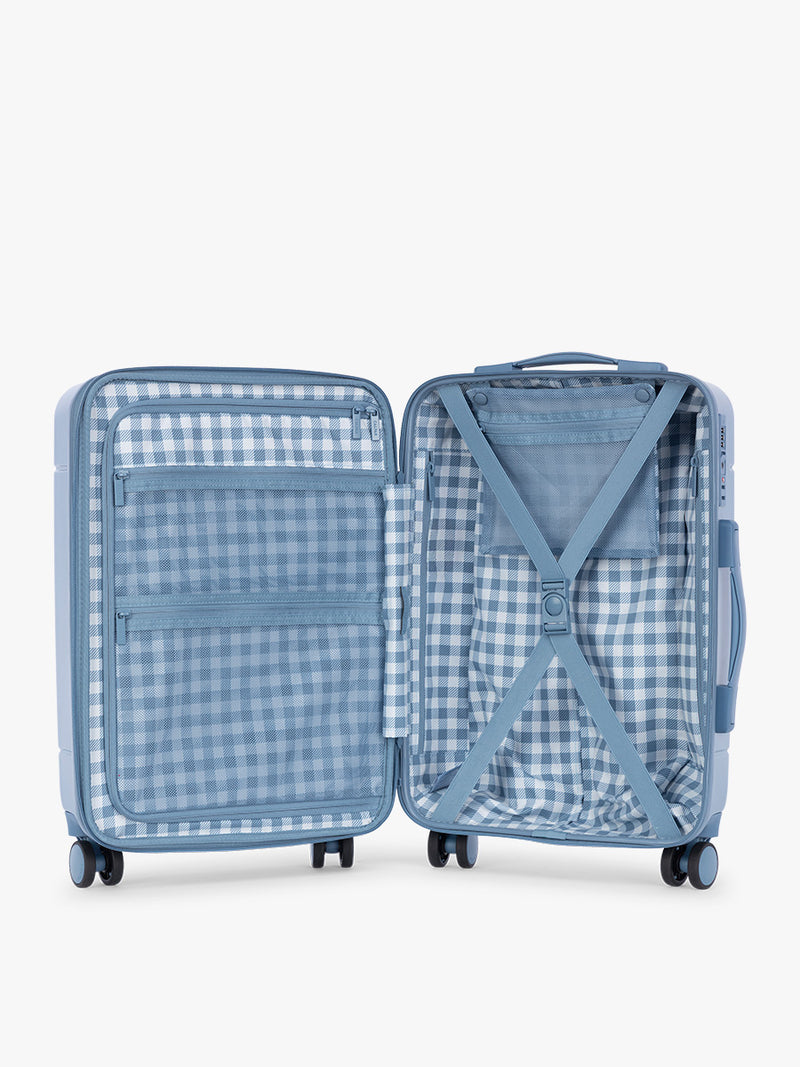 Opened view of CALPAK Hue Large Luggage in light blue French Blue and blue and white gingham interior