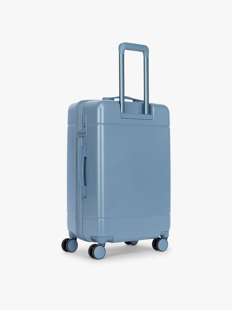 Back side of CALPAK Hue Medium Luggage in light blue French Blue and blue and white gingham interior