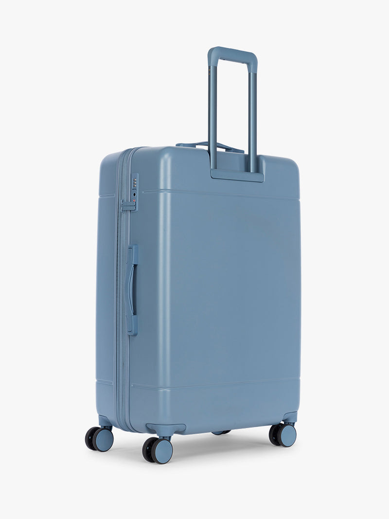 Back side of CALPAK Hue Large Luggage in light blue French Blue and blue and white gingham interior