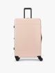 CALPAK Hue Large Luggage in light pink Rose Quartz with handle and wheels on a white background; LHU1028-ROSE-QUARTZ