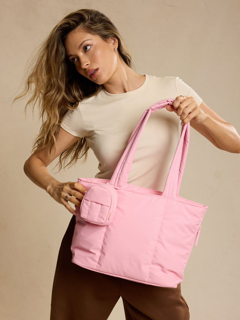Model holding CALPAK Luka Mini Tote in pink Blossom
