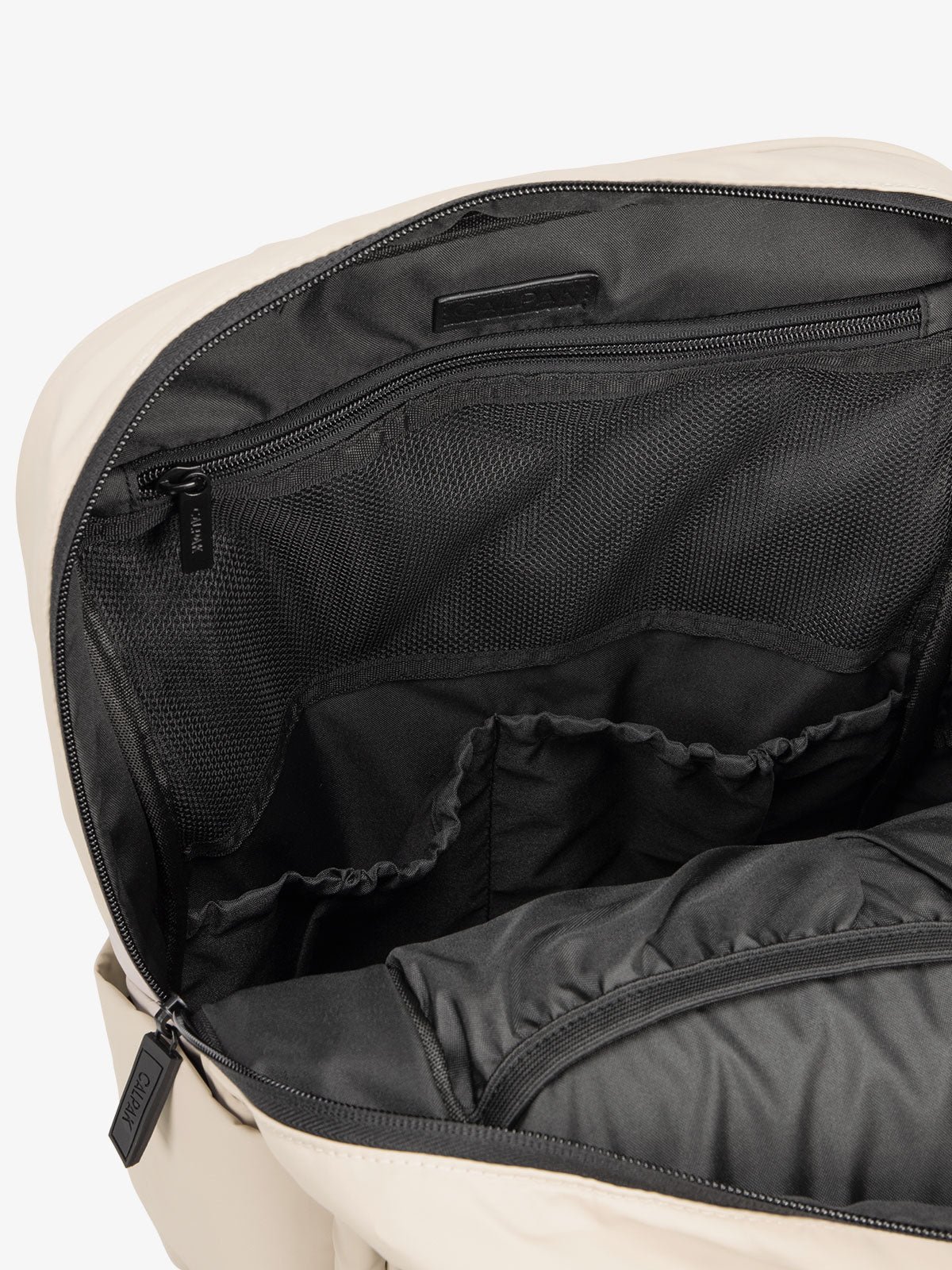 Close up of main compartment of CALPAK laptop backpack with multiple interior pockets in oatmeal
