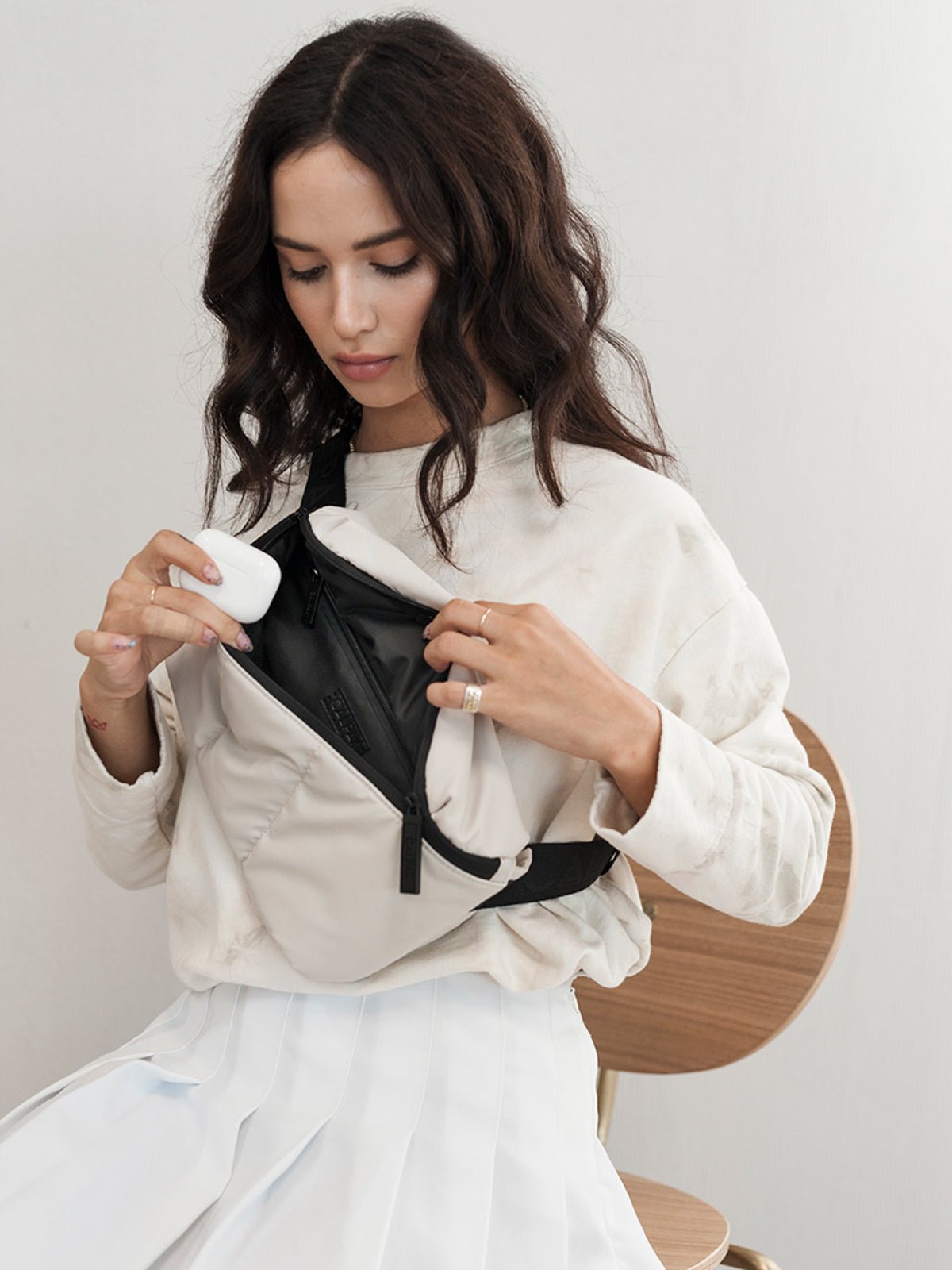 Model carrying Luka belt bag with adjustable crossbody strap in oatmeal