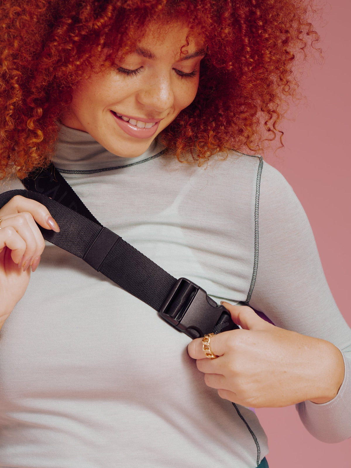 Model showing clip of adjustable strap on CALPAK Luka Belt Bag in lilac; BB1901-LILAC