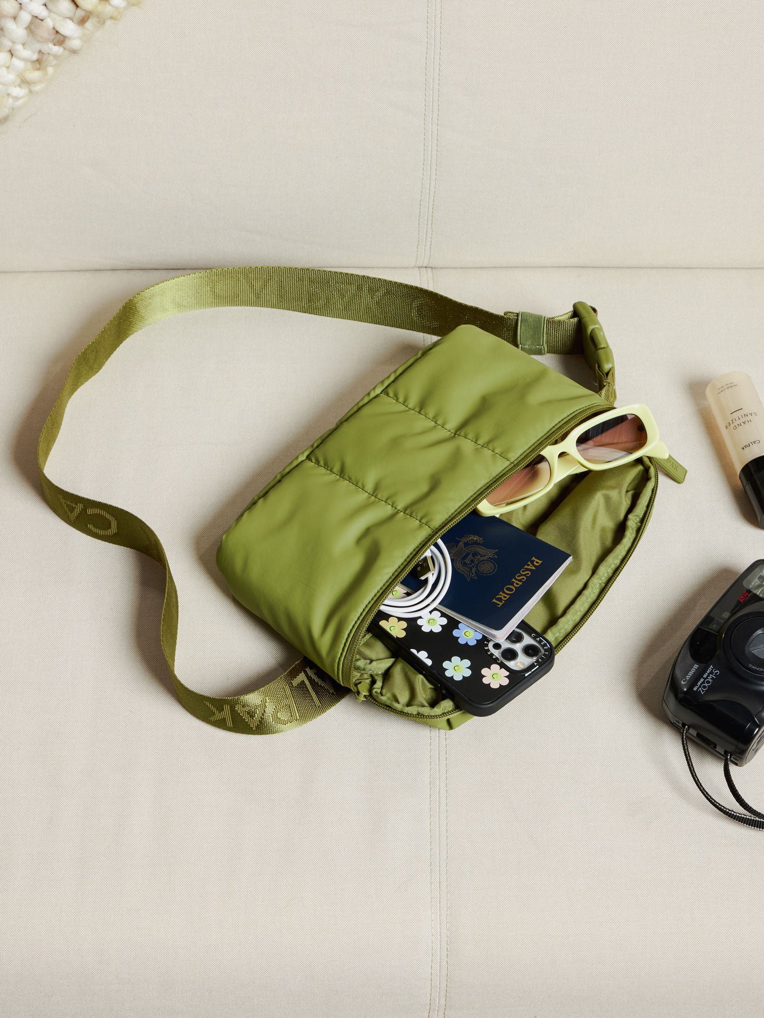Items within main pocket of CALPAK Luka Belt Bag in pistachio
