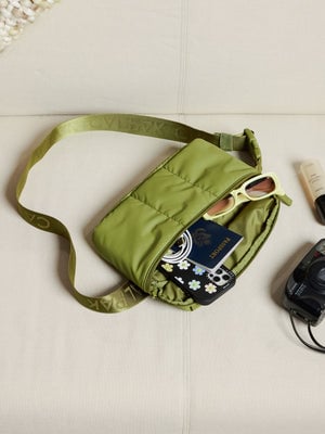 Items within main pocket of CALPAK Luka Belt Bag in pistachio; BB1901-PISTACHIO