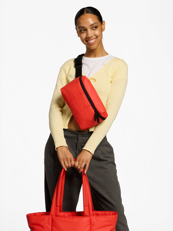 Model wearing CALPAK Luka Belt Bag as crossbody bag in rouge