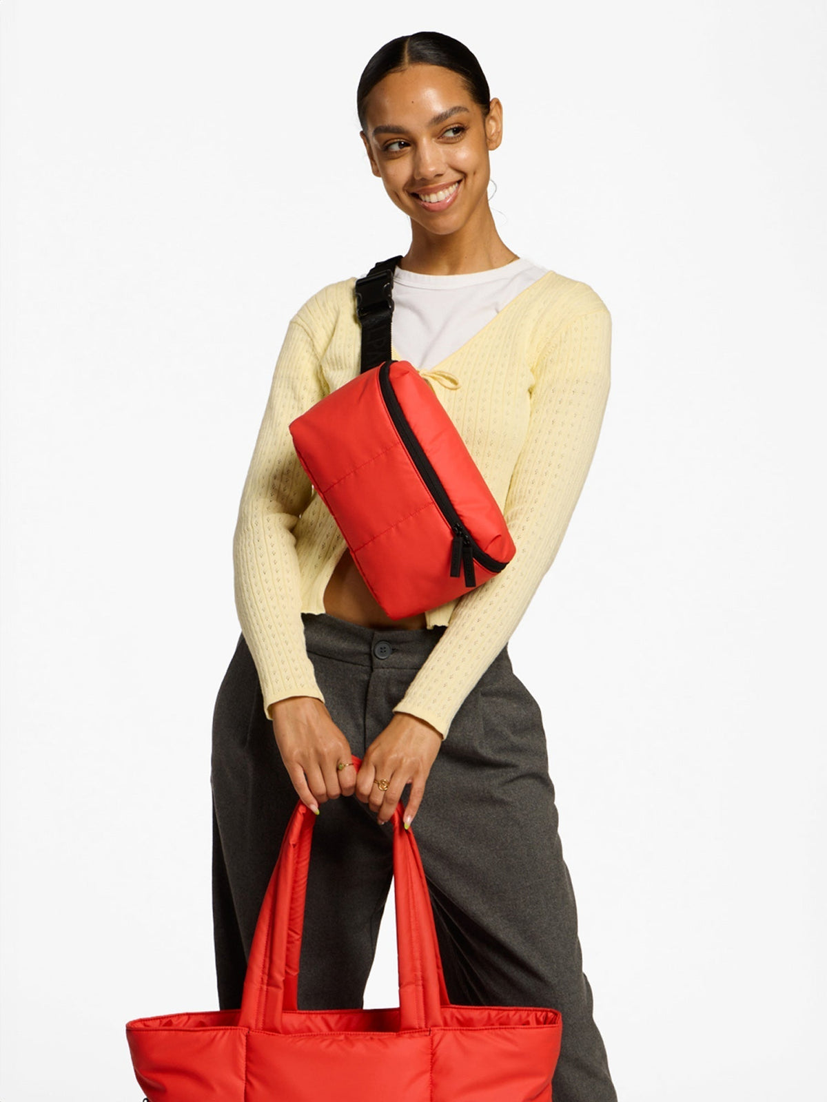 Model wearing CALPAK Luka Belt Bag as crossbody bag in rouge; BB1901-ROUGE