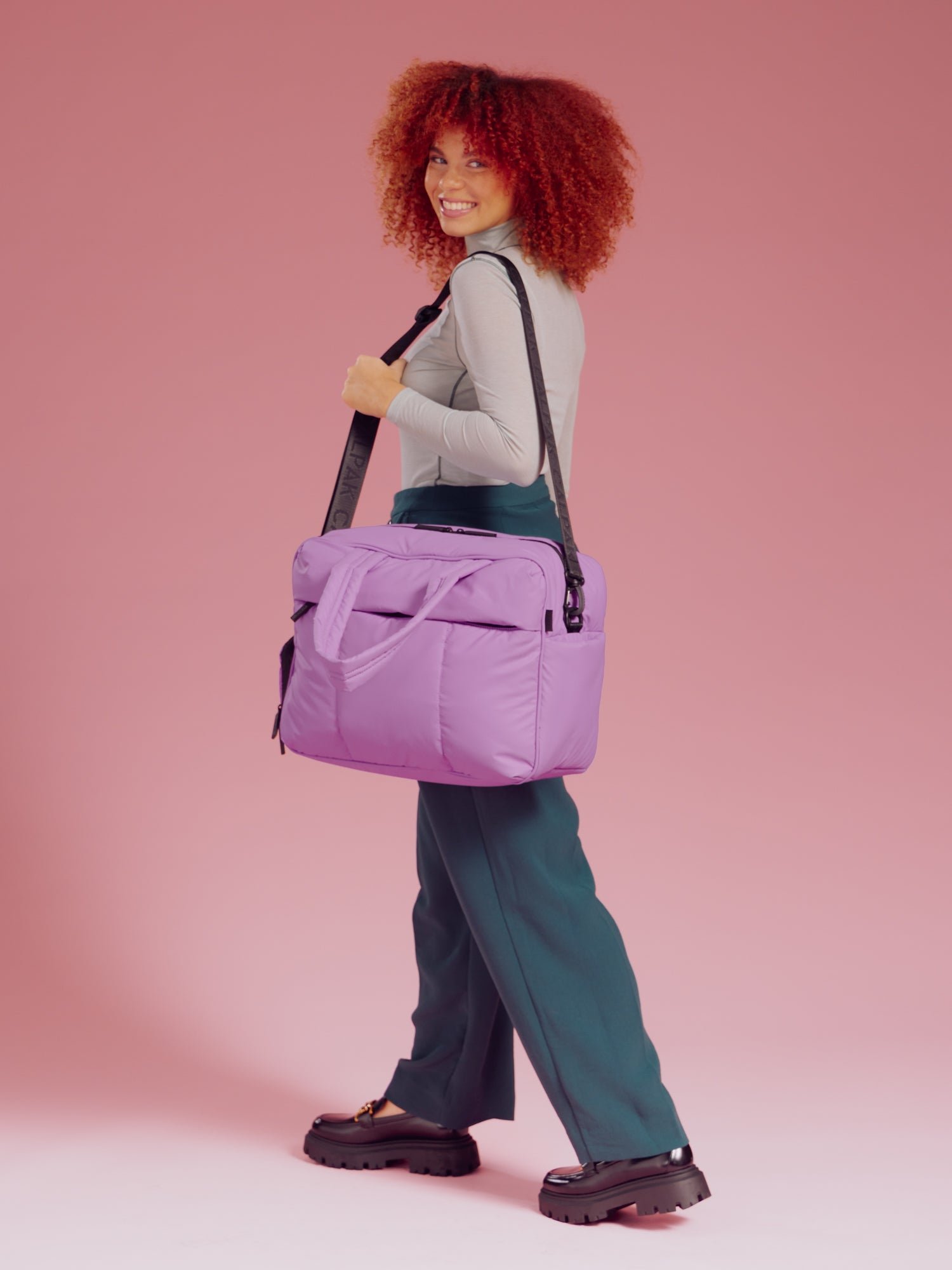 Model wearing Luka Duffel in lavender lilac over should with removable strap
