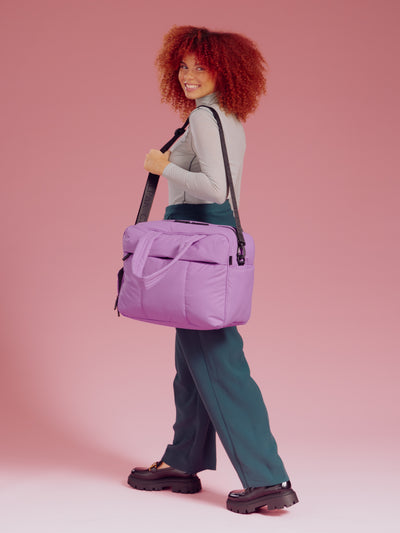 Model wearing Luka Duffel in lavender lilac over should with removable strap