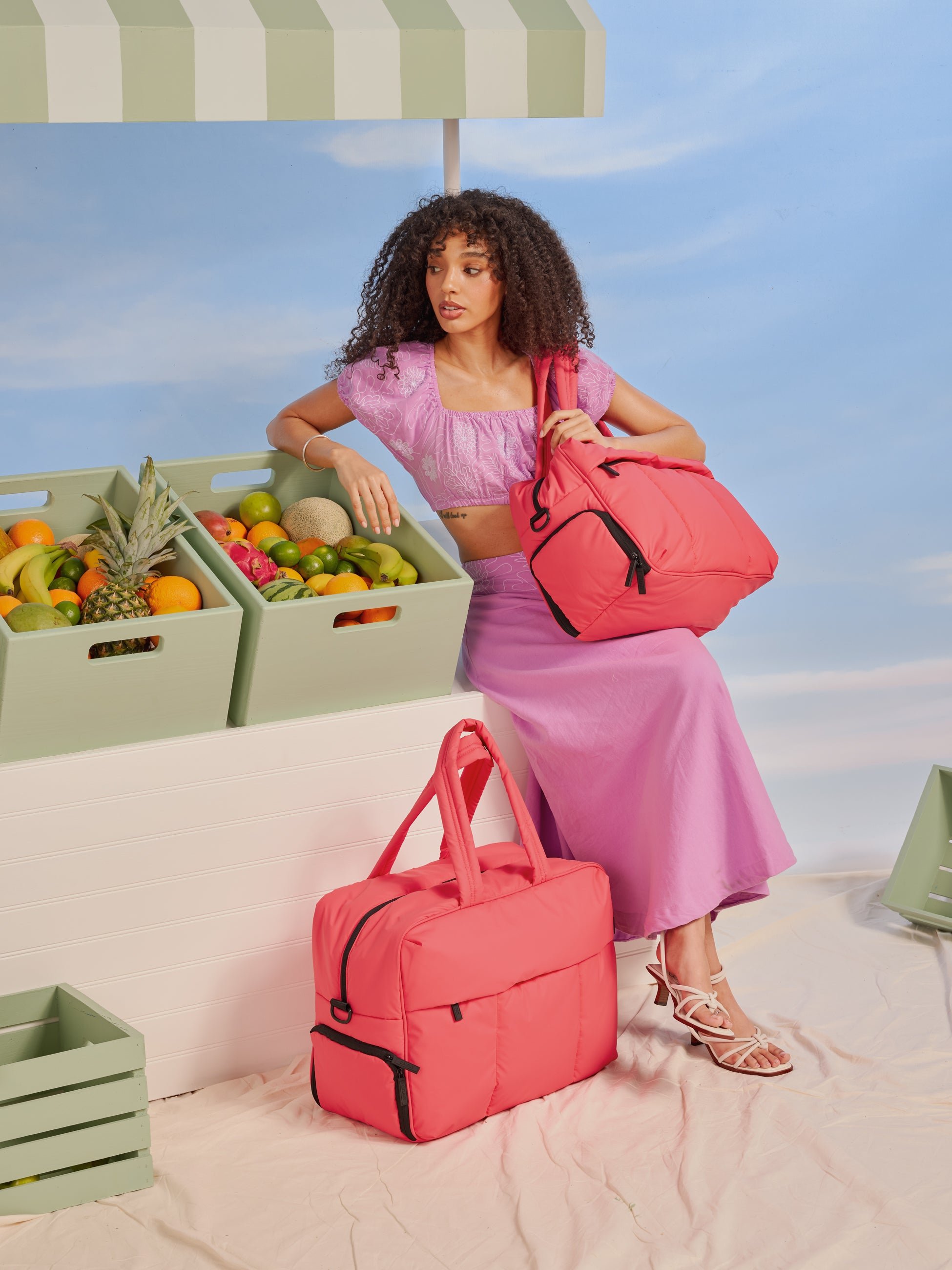 CALPAK Luka Duffel Bag carried with dual straps in watermelon pink
