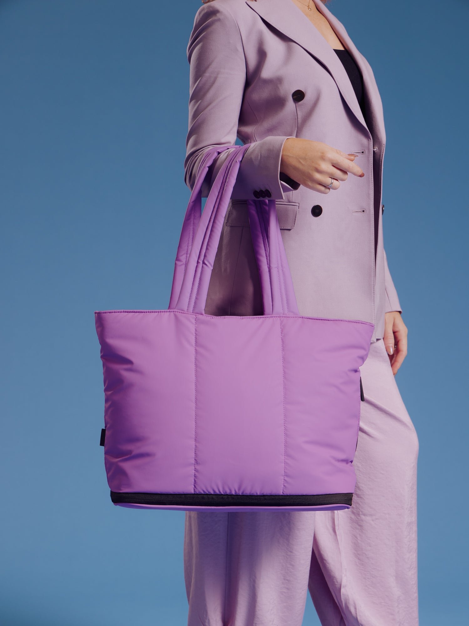 Model wearing CALPAK Luka Expandable Laptop Tote in lilac over forearm