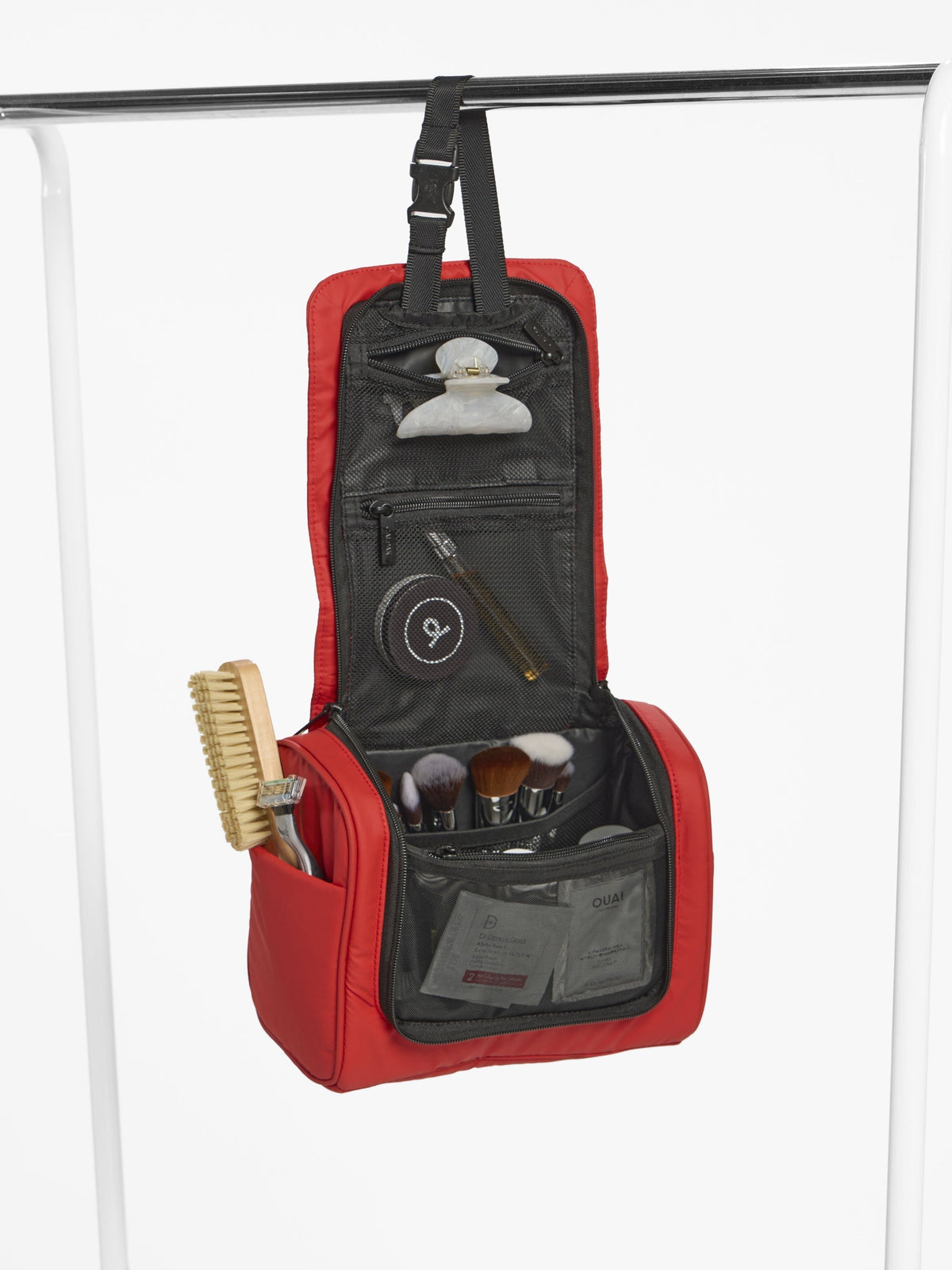 CALPAK Luka Hanging Toiletry Bag hanging by buckled strap in rouge; TLH2301-ROUGE