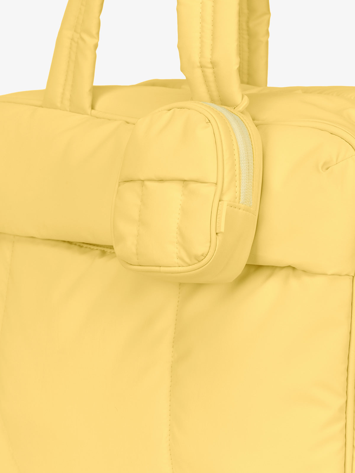CALPAK Luka mini backpack keychain attached to duffel with carabiner clip in butter yellow; AMB2201-BUTTER