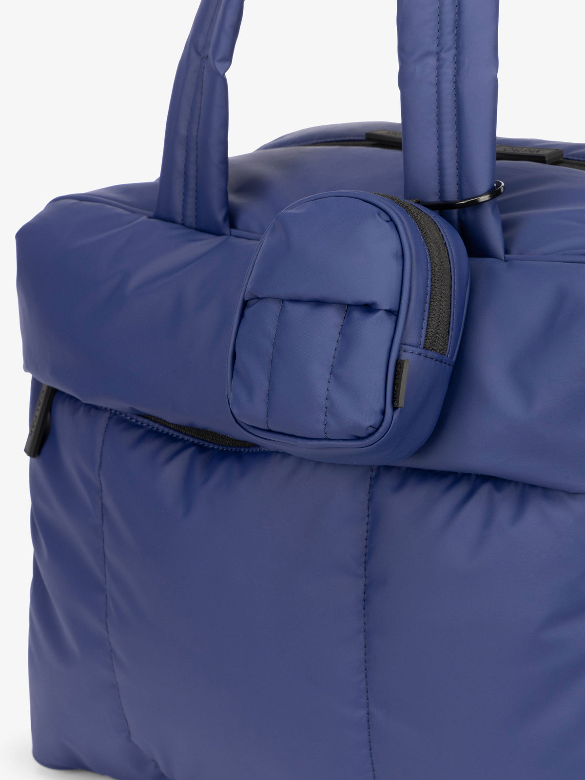 CALPAK Luka mini backpack keychain attached to duffel with carabiner clip in dark navy blue; AMB2201-NAVY