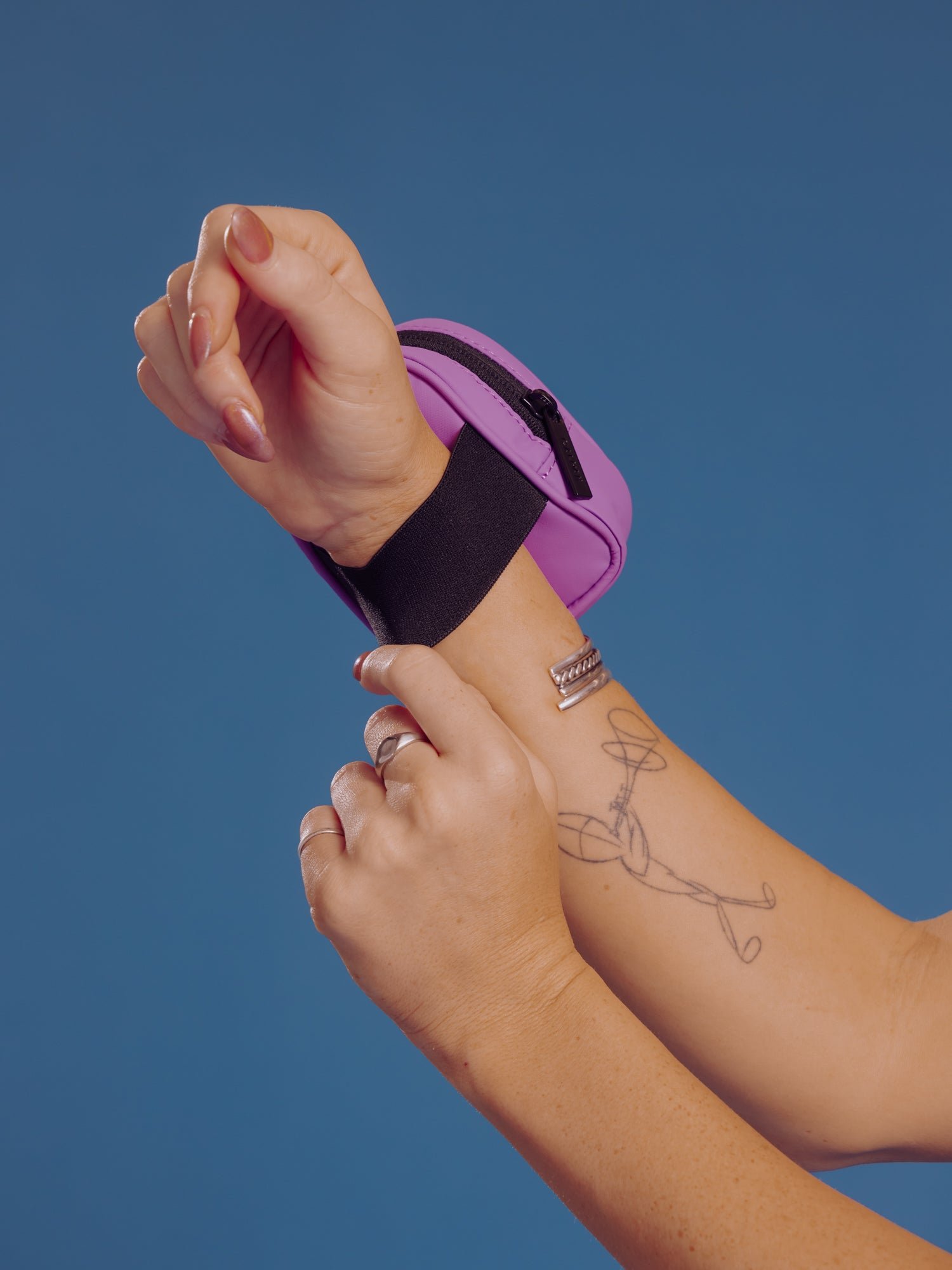 Model displaying elastic wristband of CALPAK Luka Key Pouch in lilac