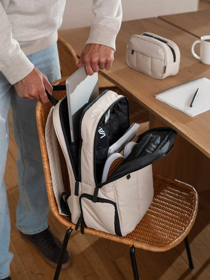 A laptop is placed in the Luka 15-inch backpack in oatmeal. The backpack offers ample storage and padding for the laptop.