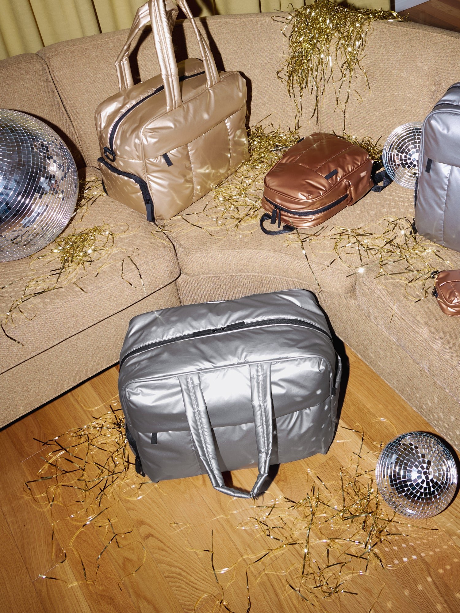 CALPAK Luka Large Duffel in metallic silver with Luka Duffel in gold and Luka Mini Backpack in copper