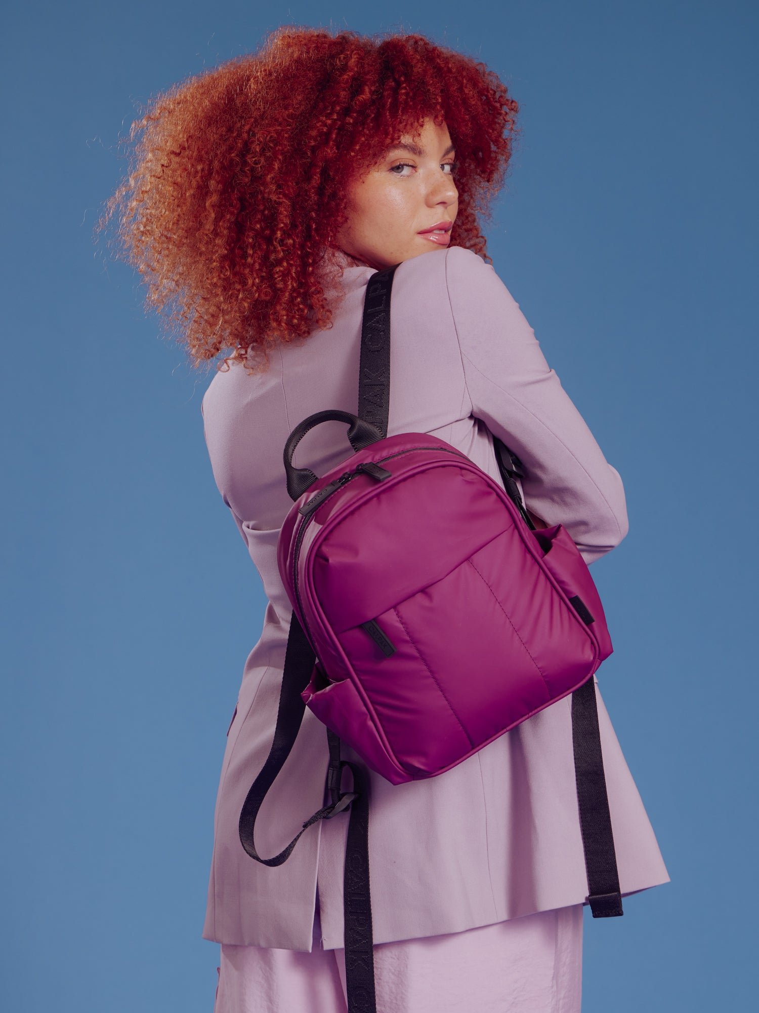 Model wearing CALPAK Luka Mini Backpack in plum
