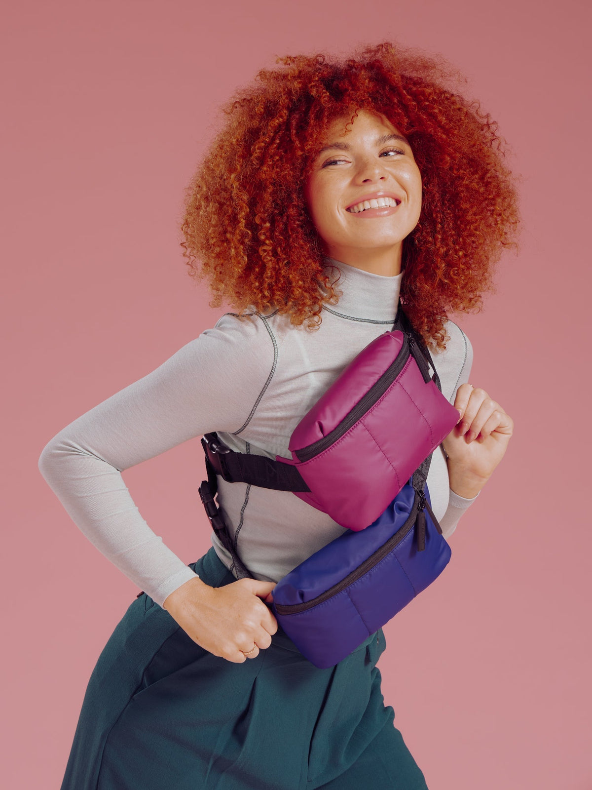 Model wearing CALPAK Luka Mini Belt Bags in plum and navy as crossbody bags; BBM2201-PLUM