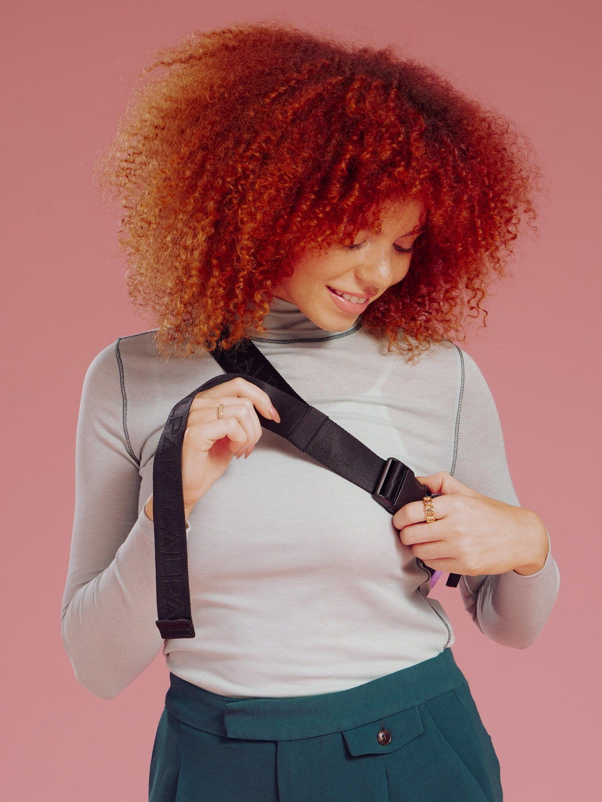 Model displaying adjustable strap of CALPAK Luka Mini Belt Bag in plum; BBM2201-PLUM