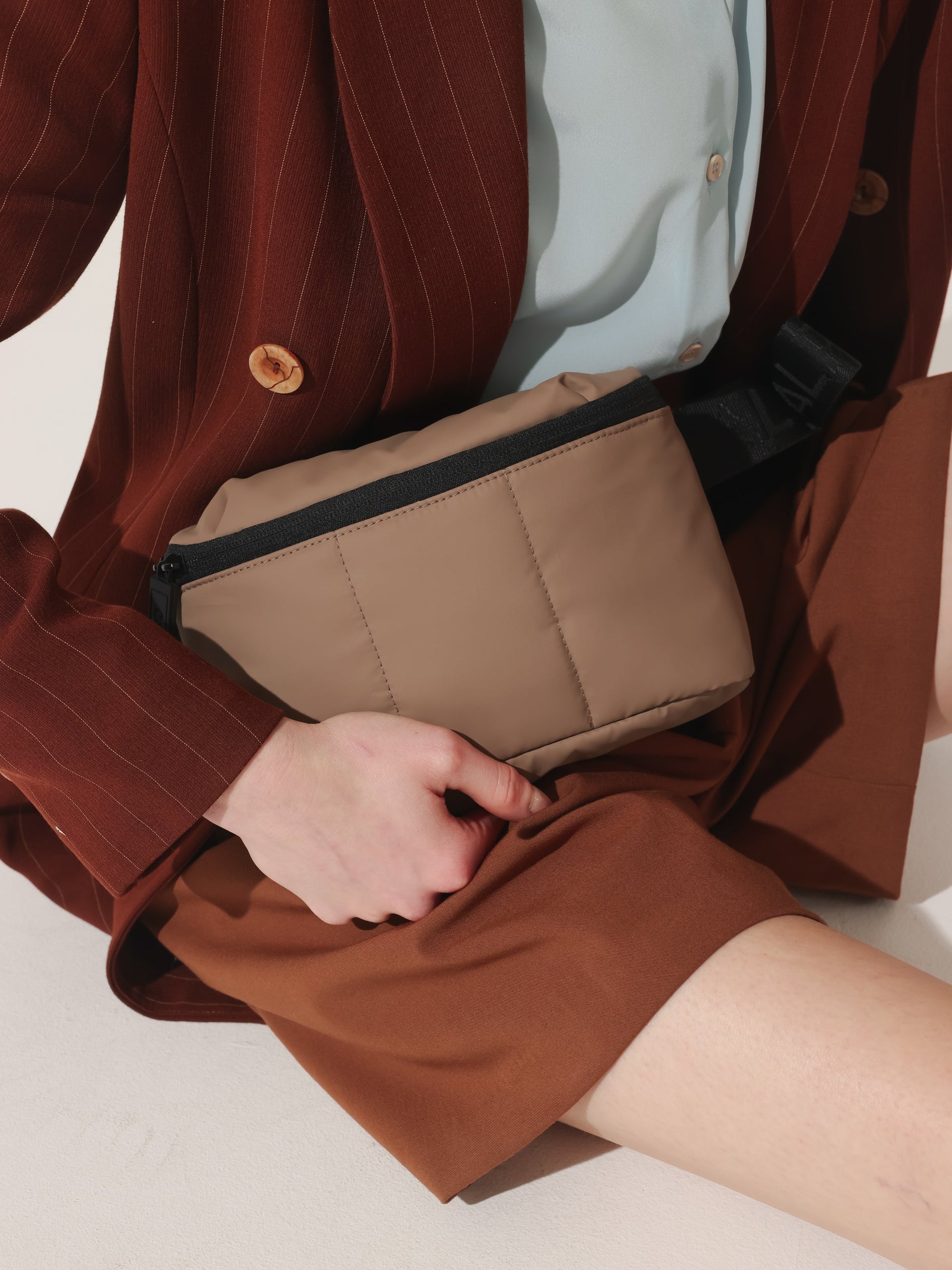 Model wearing CALPAK Luka mini crossbody fanny pack in brown; BBM2201-CHOCOLATE