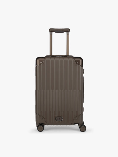 CALPAK Vault brown Mushroom hard-shell spinner Carry On Luggage with a telescoping handle extended, featuring a black leatherette side handle and trim, set against a plain light gray background; LVT1020-MUSHROOM view 1