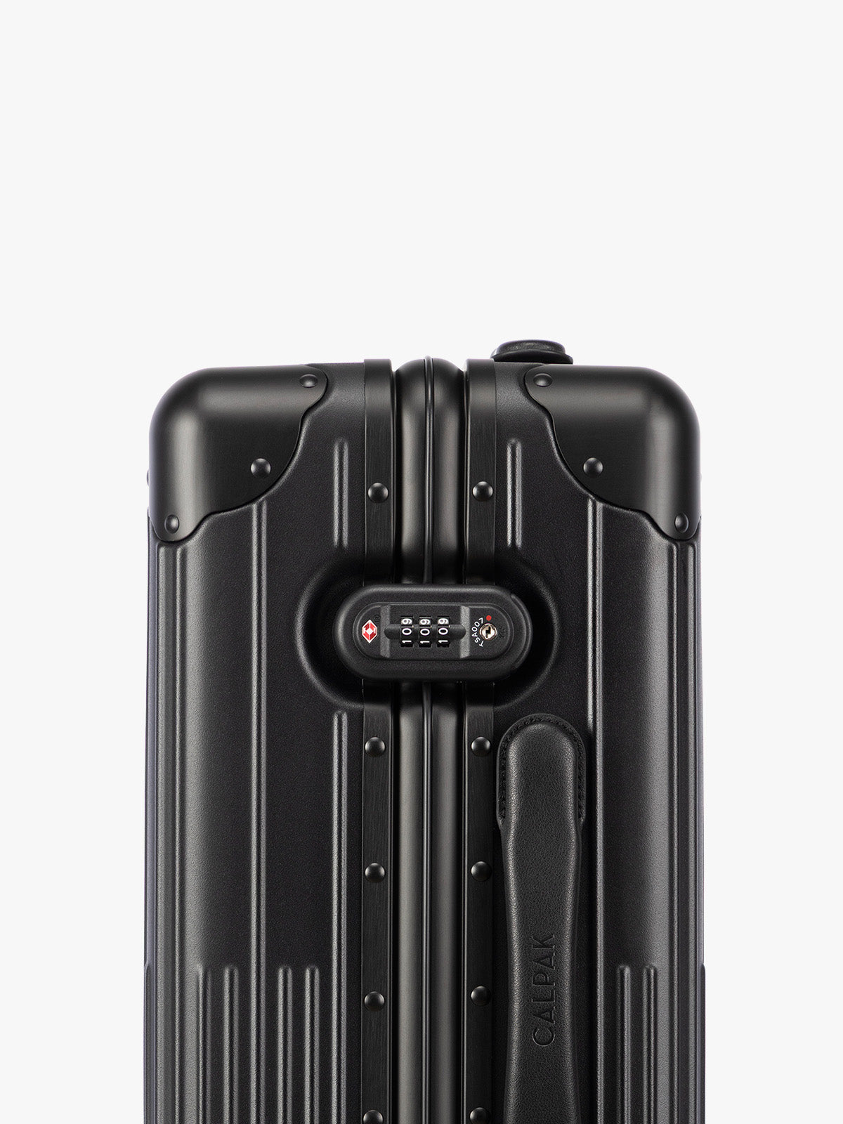 Close up of TSA approved lock of CALPAK Vault black Onyx hard-shell spinner Carry On Luggage with a telescoping handle extended, featuring a Black leatherette side handle and trim, set against a plain light gray background; LVT1020-ONYX