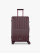 CALPAK Vault Luggage in Medium Dark Cherry deep red hard-shell spinner suitcase with a ribbed vertical design, shown from the front against a clean white background; LVT1024-DARK-CHERRY