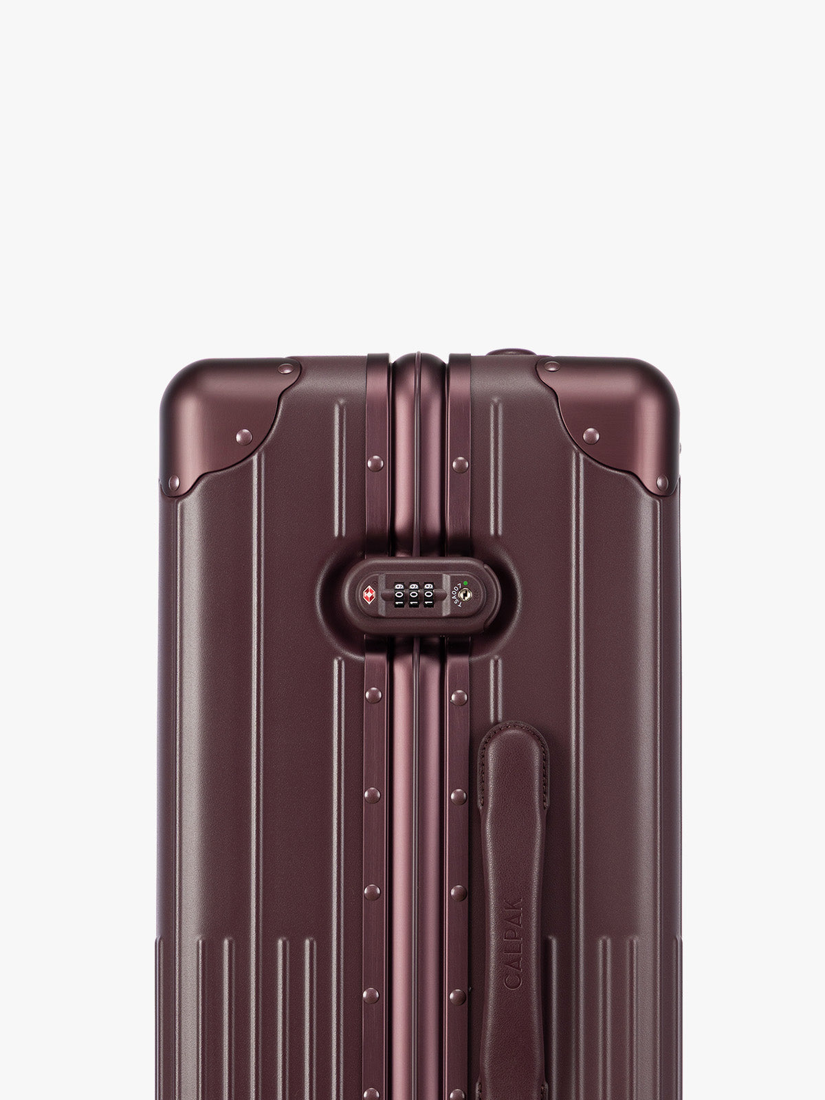 Closeup of TSA Lock of CALPAK Vault Luggage Dark Cherry deep red hard-shell spinner suitcase with a ribbed vertical design, shown from the front against a clean white background; LVT1024-DARK-CHERRY