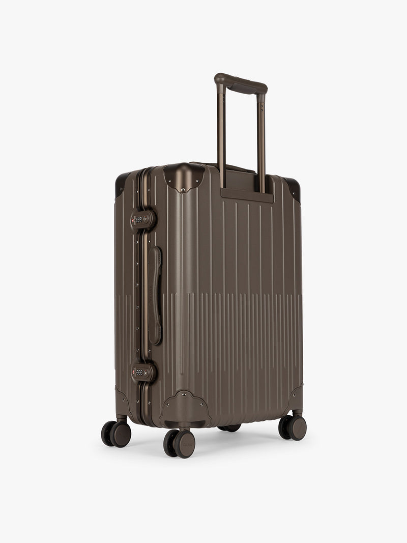 Backside of CALPAK Vault luggage brown Mushroom hard-shell spinner suitcase with a ribbed vertical design, shown from the front against a clean white background