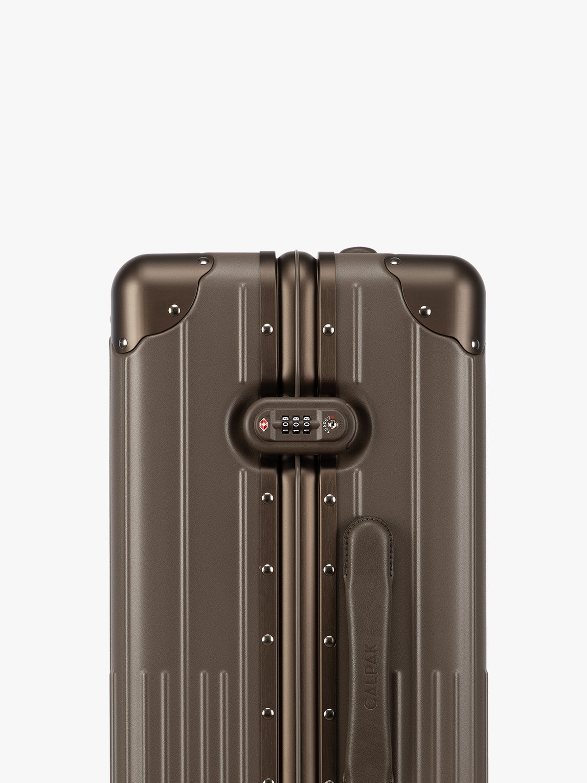 Closeup of TSA-approved lock of CALPAK Vault luggage brown Mushroom hard-shell spinner suitcase with a ribbed vertical design, shown from the front against a clean white background; LVT1024-MUSHROOM