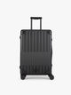 CALPAK Vault Luggage Onyx black hard-shell spinner suitcase with a ribbed vertical design, shown from the front against a clean white background; LVT1024-ONYX