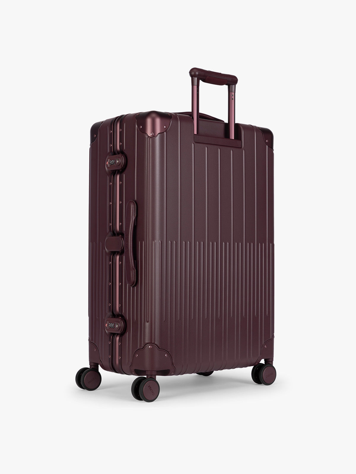 Backside of CALPAK Large Vault Luggage in deep red Dark Cherry with hard-shell spinner suitcase with a ribbed vertical design, shown from the front on a light gray background; LVT1028-DARK-CHERRY