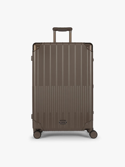 CALPAK Large Vault Luggage in brown Mushroom with hard-shell spinner suitcase with a ribbed vertical design, shown from the front on a light gray background; LVT1028-MUSHROOM view 1