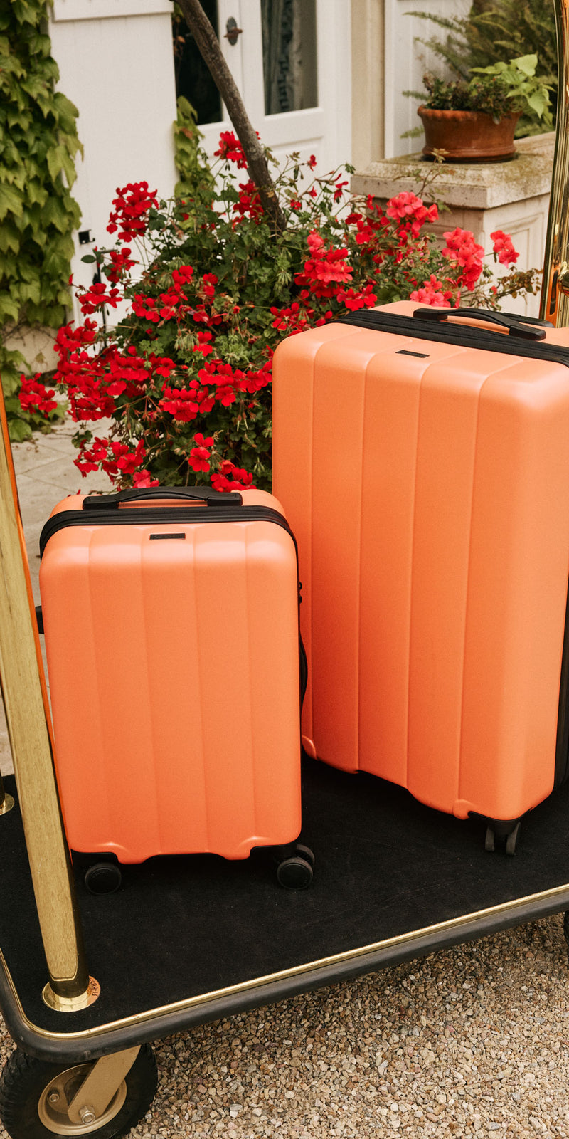 CALPAK Evry Starter Bundle in orange Persimmon on hotel luggage trolley