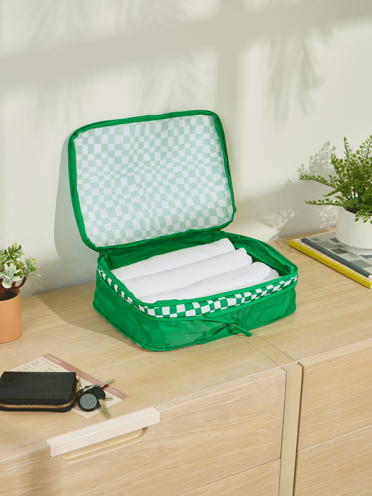CALPAK Medium Compression Packing Cubes made of durable material and expandable by 4.5" in green checkerboard