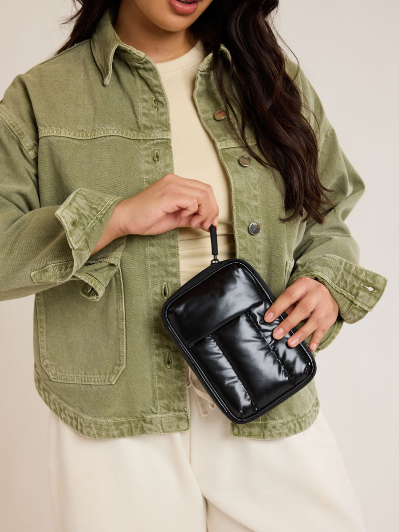 Model closing the Front view of CALPAK Luka Zippered Passport Wallet in Glazed Black