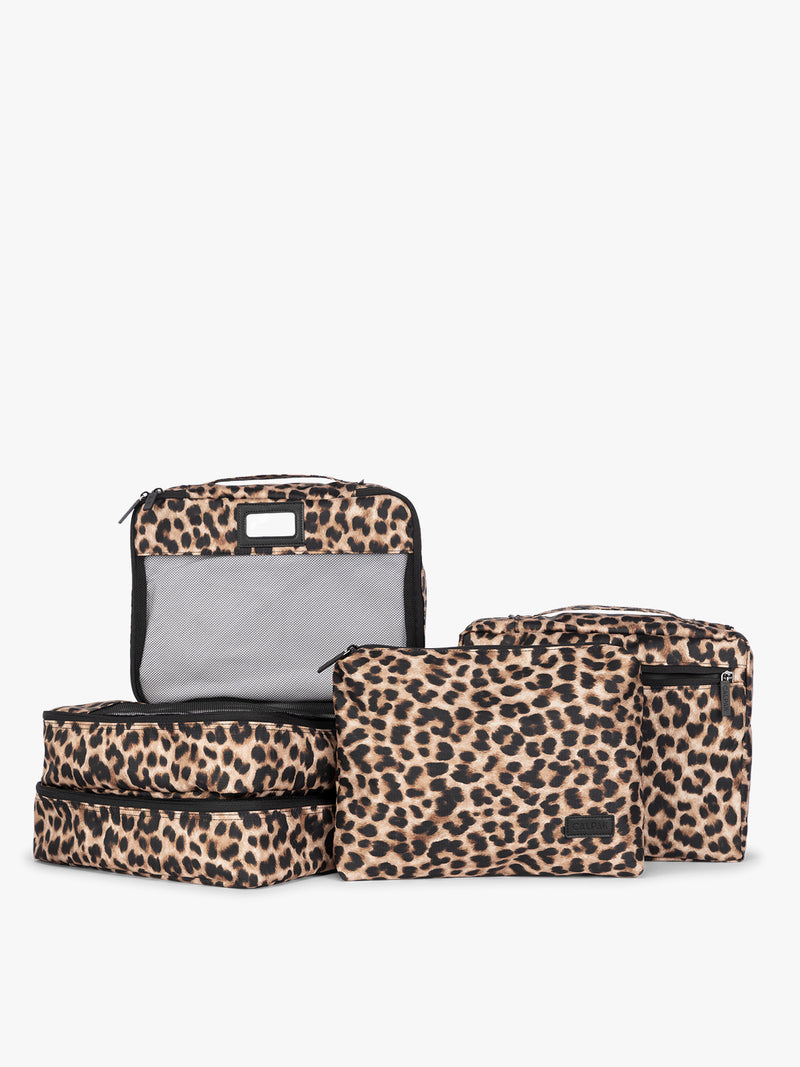Tan and black animal pattern Leopard CALPAK 5-piece travel packing cubes set which includes three mesh cubes, a flat cube, and a zippered organizer, displayed on a clean white background