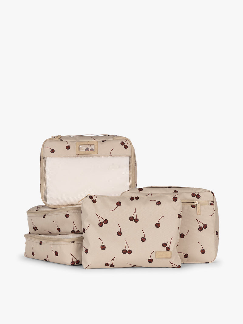 CALPAK Packing Cubes 5pc Set in beige with cherry print in Oatmeal Cherry on a white background