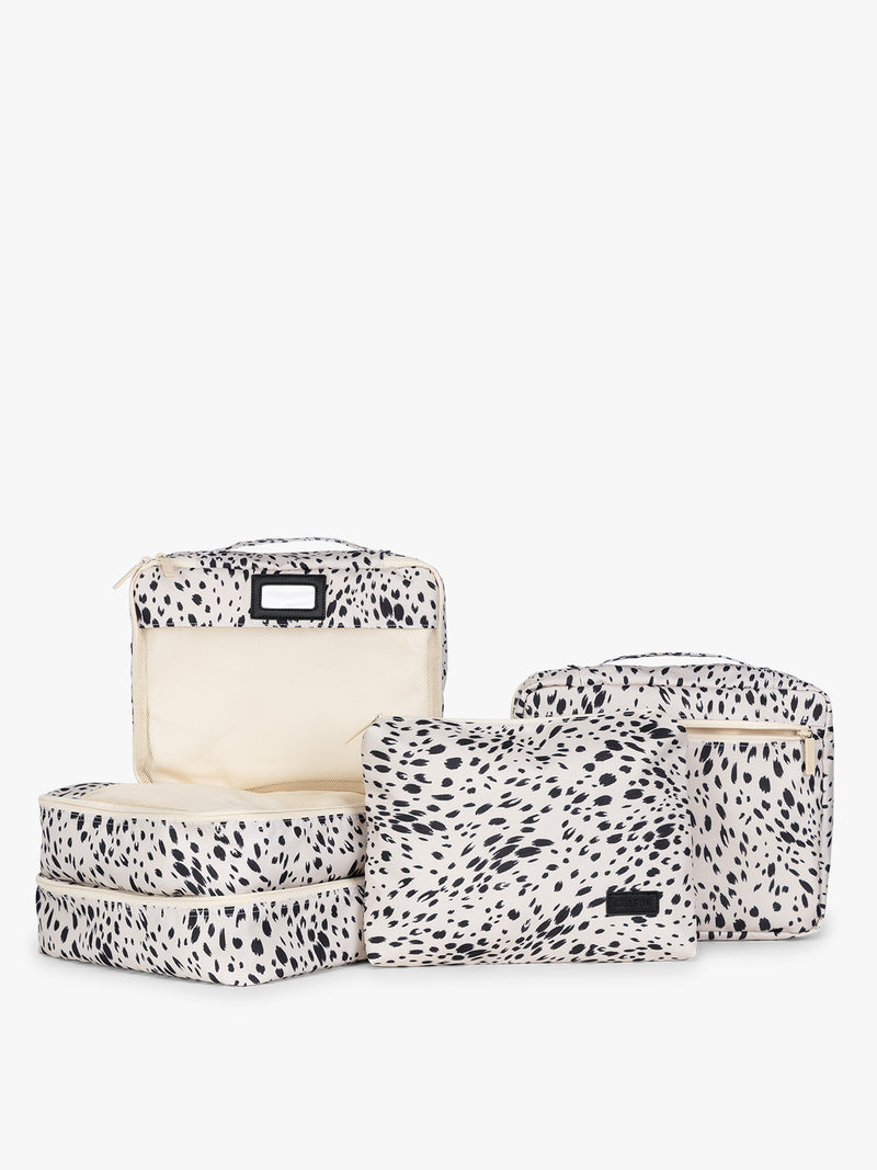 White and black animal pattern Snow Leopard CALPAK 5-piece travel packing cubes set which includes three mesh cubes, a flat cube, and a zippered organizer, displayed on a clean white background