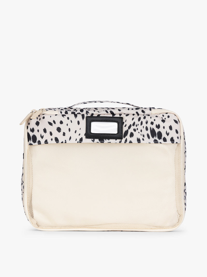 White and black animal print Snow Leopard CALPAK 5-piece travel packing cubes set with close up of mesh cubes with a label, displayed on a clean white background