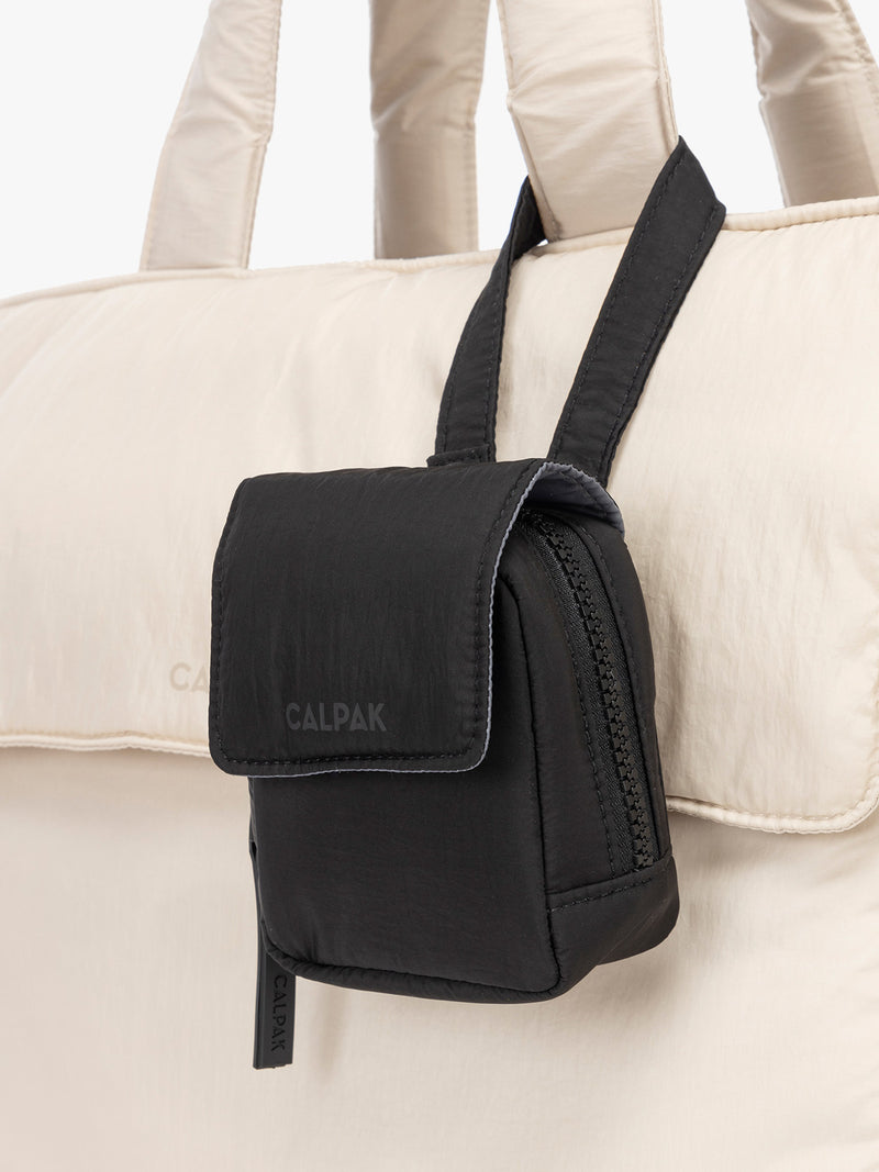 CALPAK Baby Collection Pacifier Pouch in Black clipped onto white bag