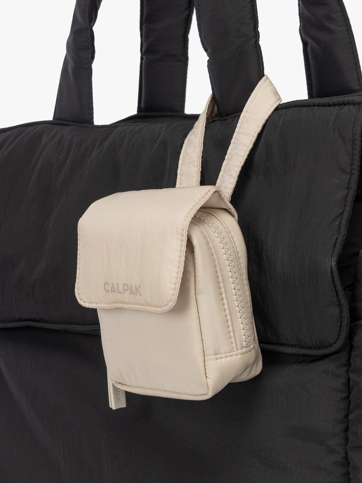 CALPAK Baby Collection Pacifier Pouch in white Oatmeal clipped onto black bag; PCB2501-OATMEAL