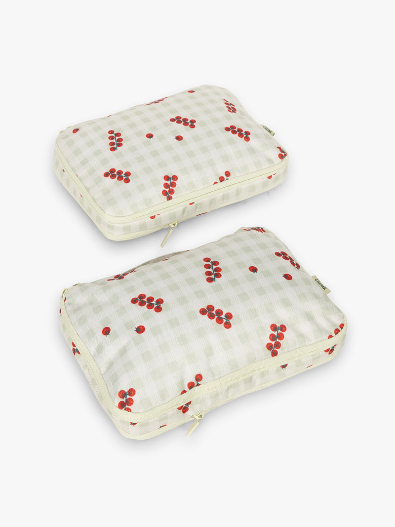 CALPAK Medium Compression Packing Cubes in white and green gingham pattern with tomato print
