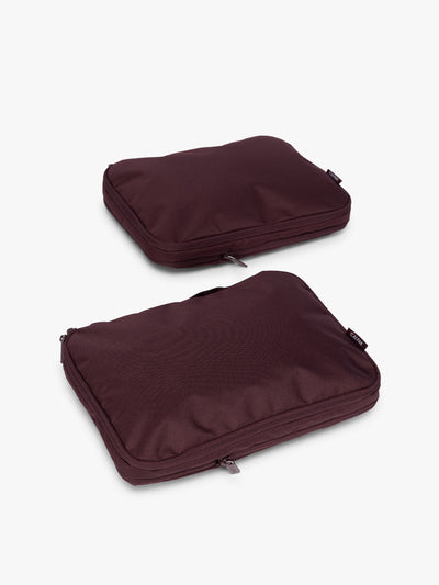 Two burgundy Dark Cherry CALPAK Medium Compression Packing Cubes with zippers shown on a clean white background; PCC2201-DARK-CHERRY view 1
