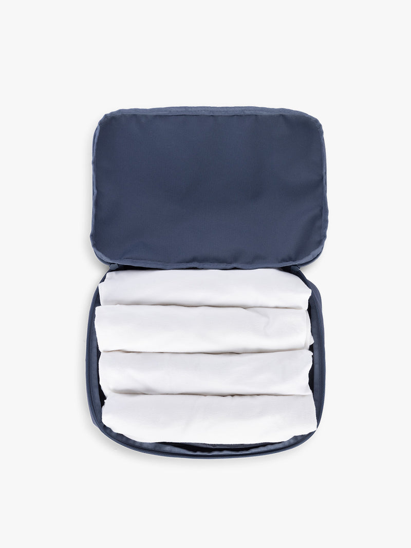 Towels rolled up in CALPAK Medium Compression Packing Cubes (Set of 2) in dark blue Indigo