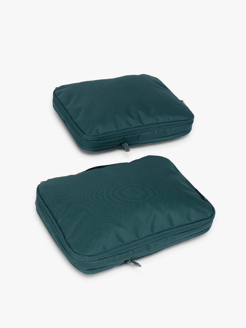 Two dark green teal Kale CALPAK Medium Compression Packing Cubes with zippers shown on a clean white background